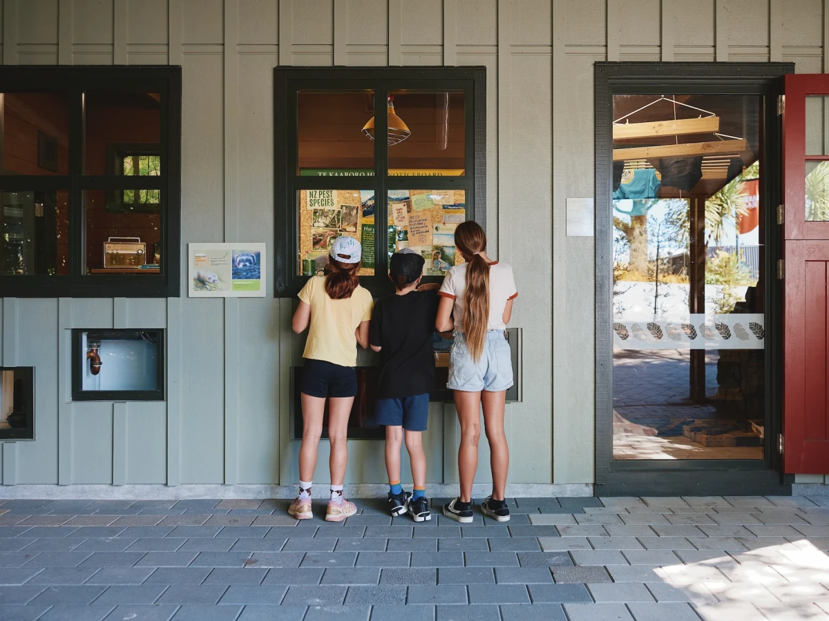 Kids peeking through a window at the zoo