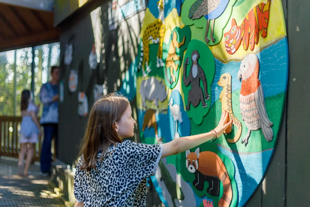 A girl touching an animal mural at Hamilton Zoo