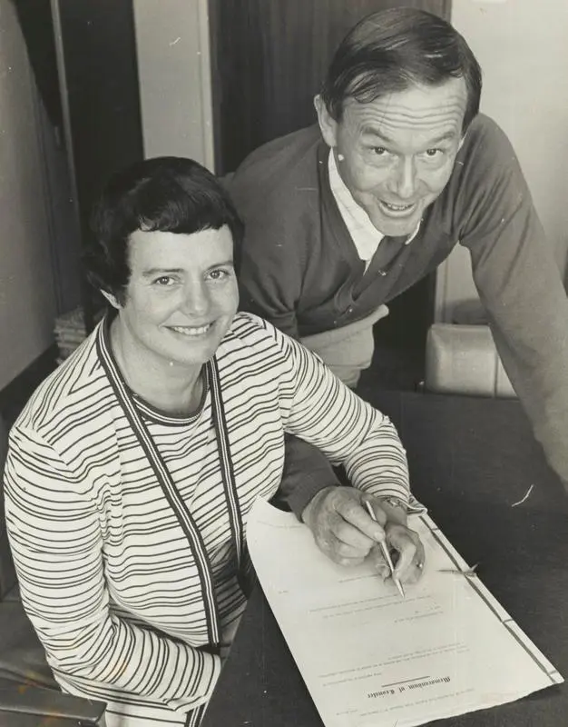 A man and a woman signing a document together